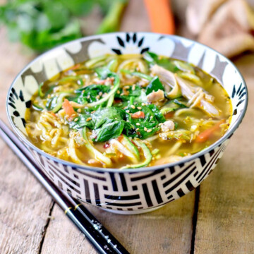 Keto chicken ramen in a black and white bowl on a wooden table.