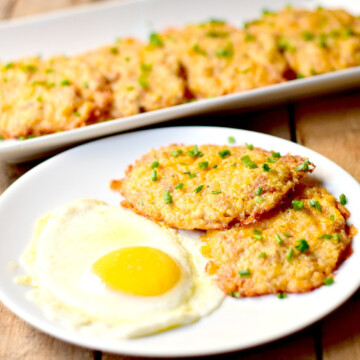 Low-Carb Cheesy Cauliflower Hash Browns on a white plate with a sunny side up egg.