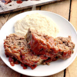 Keto homestyle meatloaf on a white plate with mashed cauliflower.
