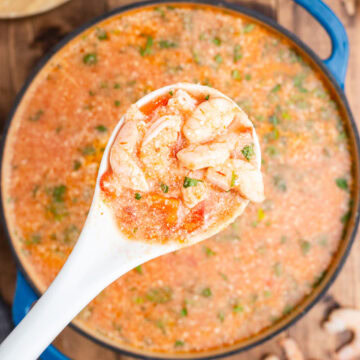 Overhead view of a large Dutch oven filled with Keto Brazillian shrimp stew on a wooden tabel.