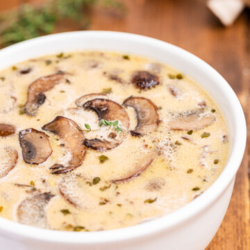 Keto cream of mushroom soup in a white bowl on a wooden table.