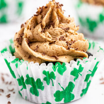 Closeup of a keto Irish coffee cupcake in a white cupcake liner with green shamrocks.