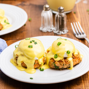 Keto salmon eggs benedict on a white plate on a wooden table.