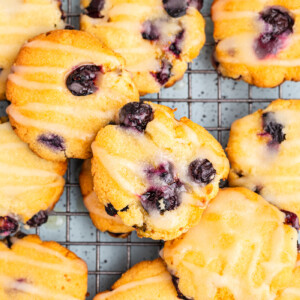 Overhead view of Keto Blueberry Cheesecake Cookies with Lemon Drizzle on a wire cooling rack.