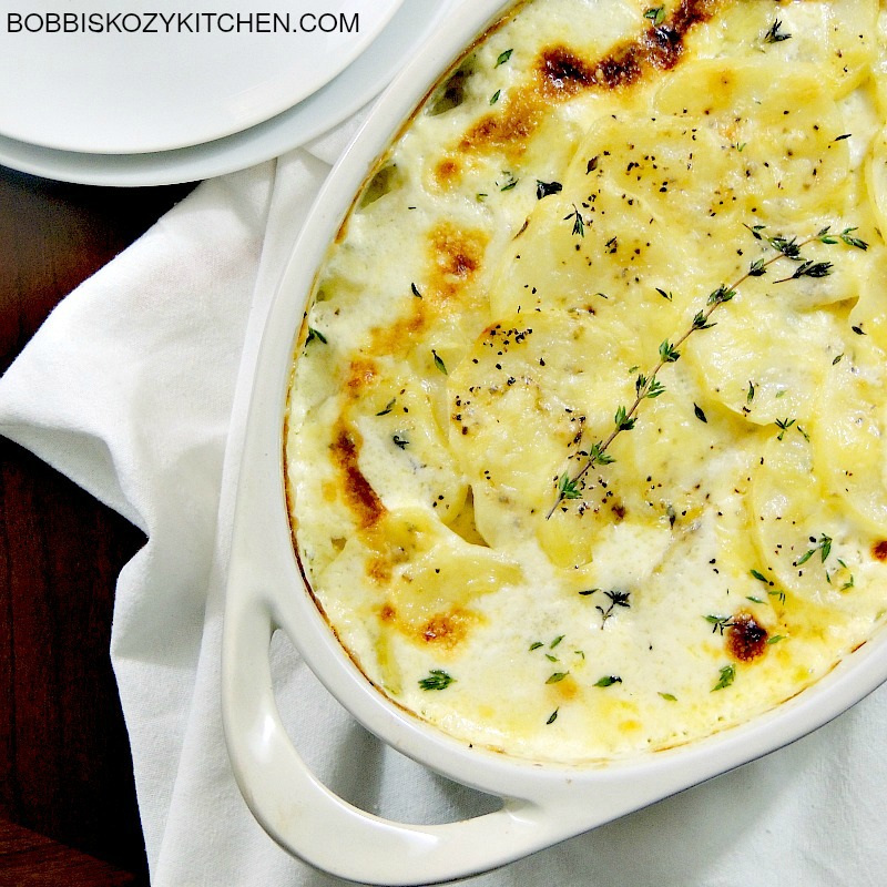 Julia Child's Gratin Dauphinois (Au Gratin Potatoes) are quite possibly my favorite potatoes ever! Potatoes, cream, cheese, and thyme? Heaven on a plate! #potatoes #thanksgiving #christmas #easter #sidedish #recipe | bobbiskozykitchen.com