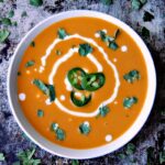 Quick Curried Squash Soup in a white bowl on a metal background.