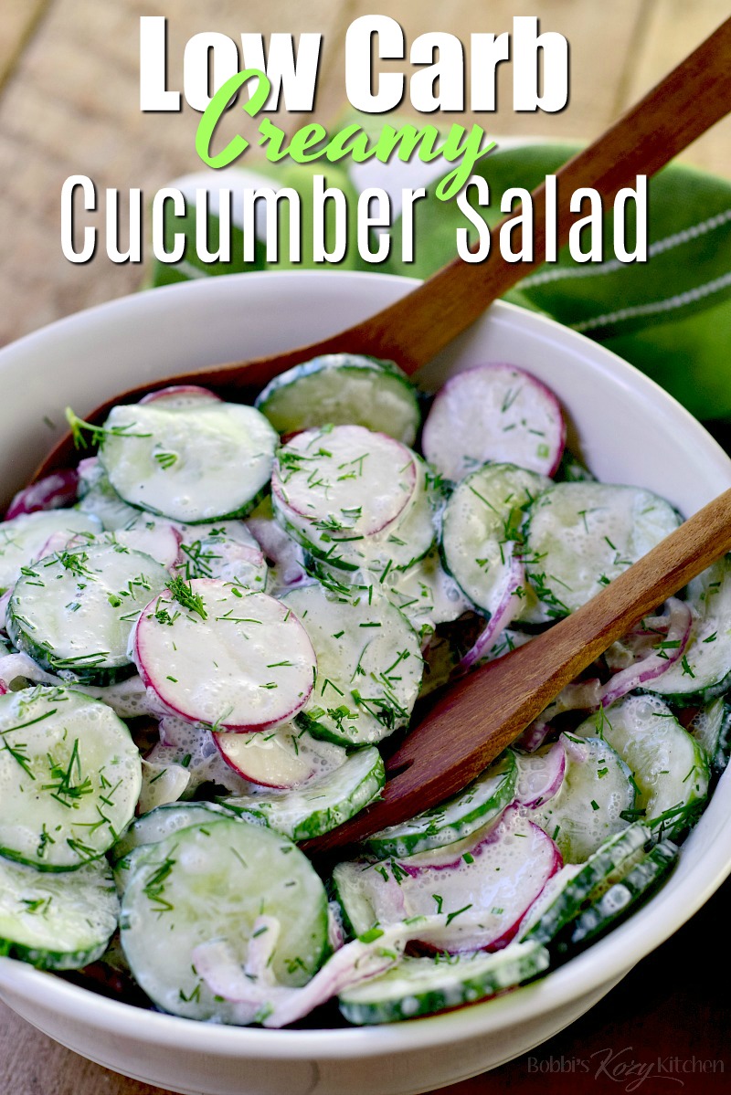 Creamy low carb cucumber salad in a bowl with wooden salad tongs.