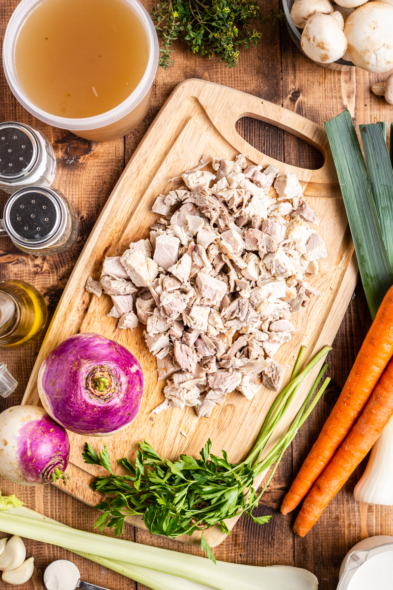 Overhead view of the ingredients for Creamy Low Carb Turkey Stew on a wooden cutting board.