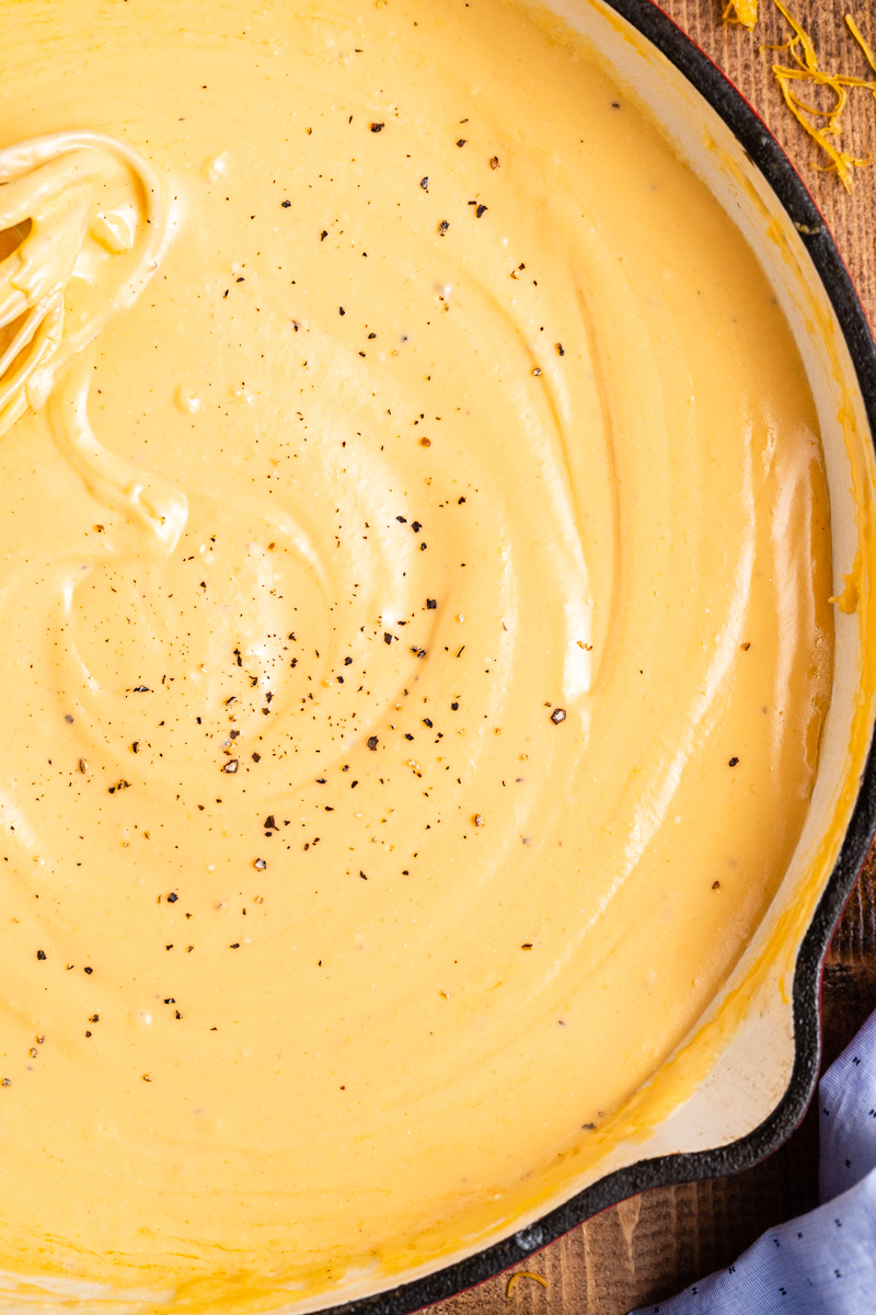 Over head photo of Easy Keto Cheese Sauce in a skillet with fresh cracked black pepper.