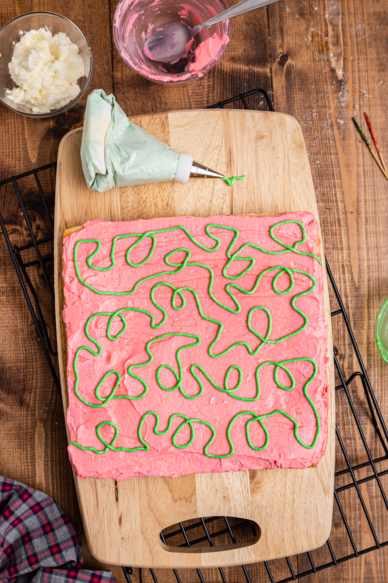 Overhead photo of Keto Sugar Cookie Bars frosted with red frosting and green squiggles.