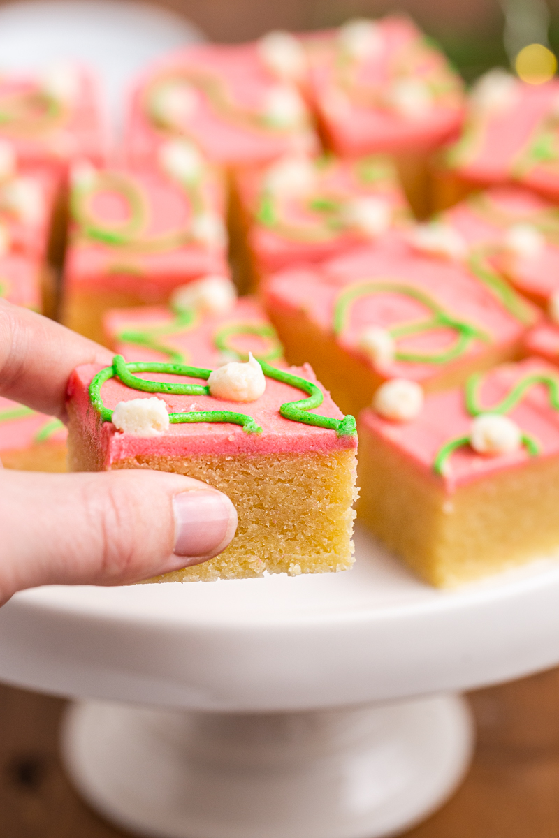 Close up photo of Keto Sugar Cookie Bars with a hand holding one close to the camera.