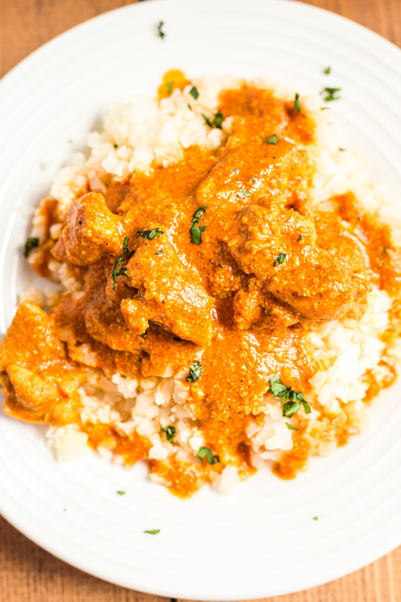 Tender chicken pieces enveloped in an aromatic and incredibly creamy curry sauce, this Low Carb Butter Chicken recipe is one of the best you will try!  #keto #lowcarb #glutenfree #indian #curry #chicken | bobbiskozykitchen.com