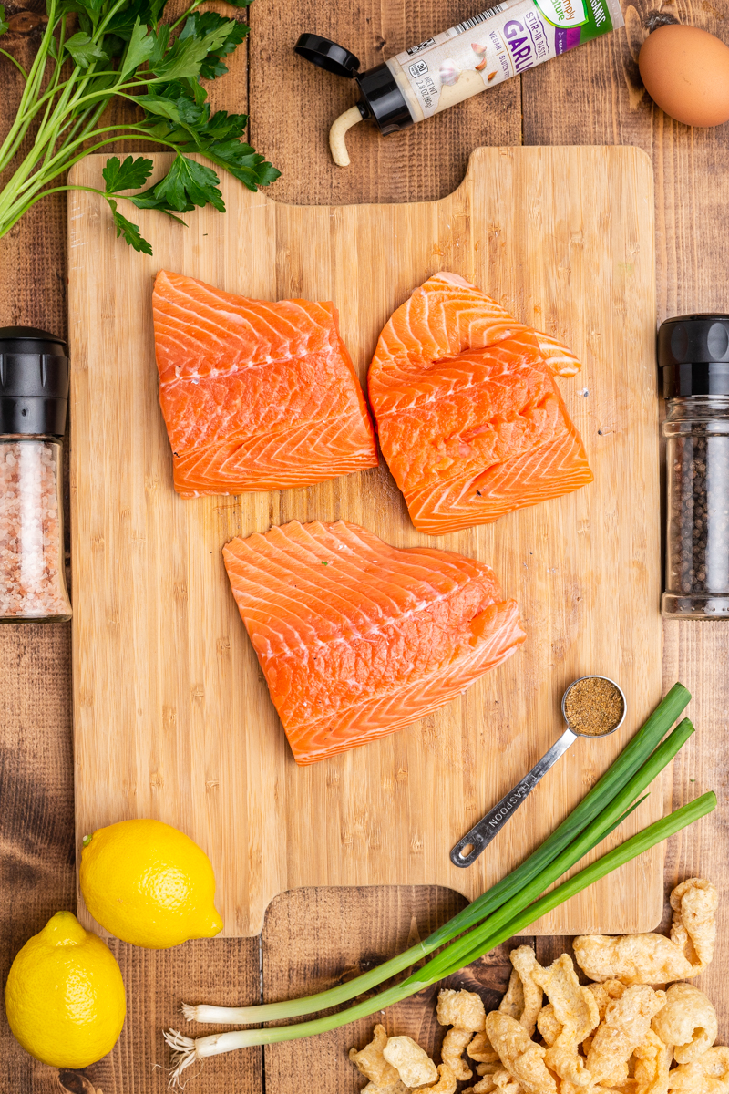 Overhead photo of the ingredients needed to make Keto Salmon Cakes (Salmon Patties) on a wooden table.