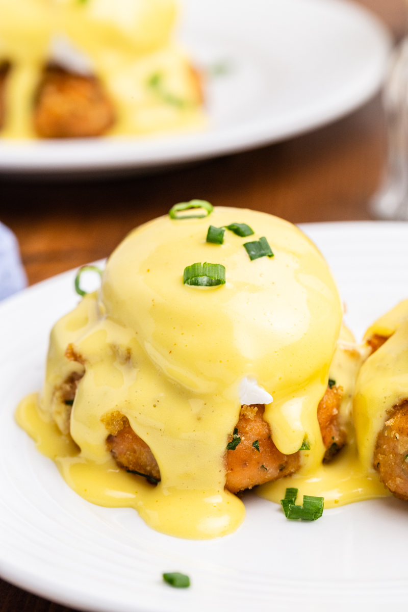 Close up photo of Keto Salmon Eggs Benedict on a white plate with chives on top.