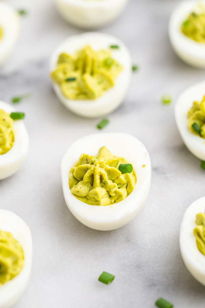 Side view of Avocado Deviled Eggs on a marble background.