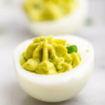 Avocado Deviled Eggs on a white marble counter.