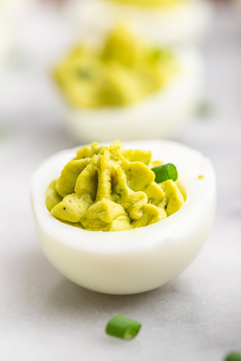 Avocado Deviled Eggs on a white marble counter.