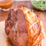 Keto Apricot Bourbon Glazed Ham on a wooden cutting board.