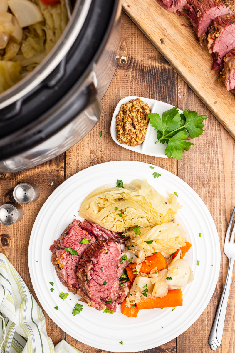 Overhead photo of cooked Keto Instant Pot Corned Beef and Cabbage on a white plate.