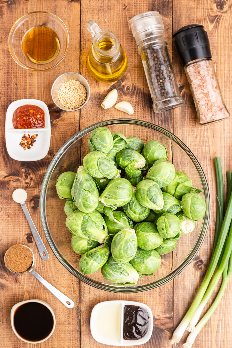 Overhead photo of the ingredients needed to make Kung Pao Brussels Sprouts on a wooden table.