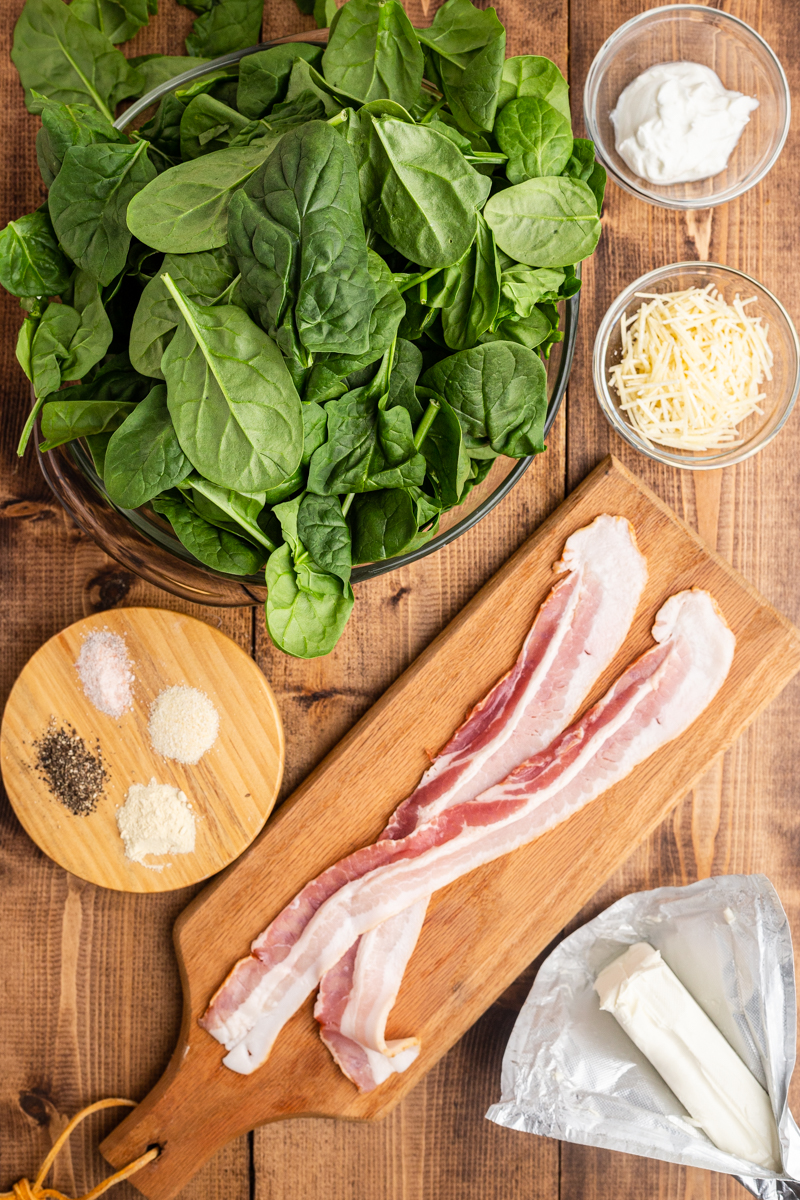 Overhead photo of the ingredients needed to make Easy Creamed Spinach on a wooden table.