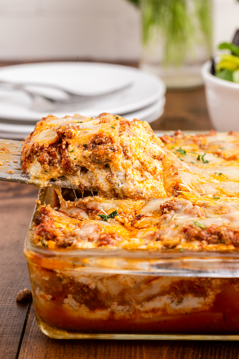 Close up photo of a serving of keto lasagna being taken from the baking dish.
