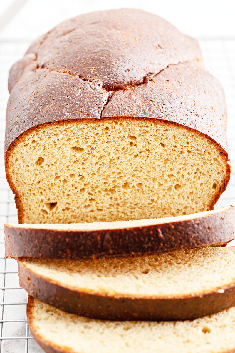 Closeup of a loaf of the best Keto Oven Baked Bread with a few slices tipped over.