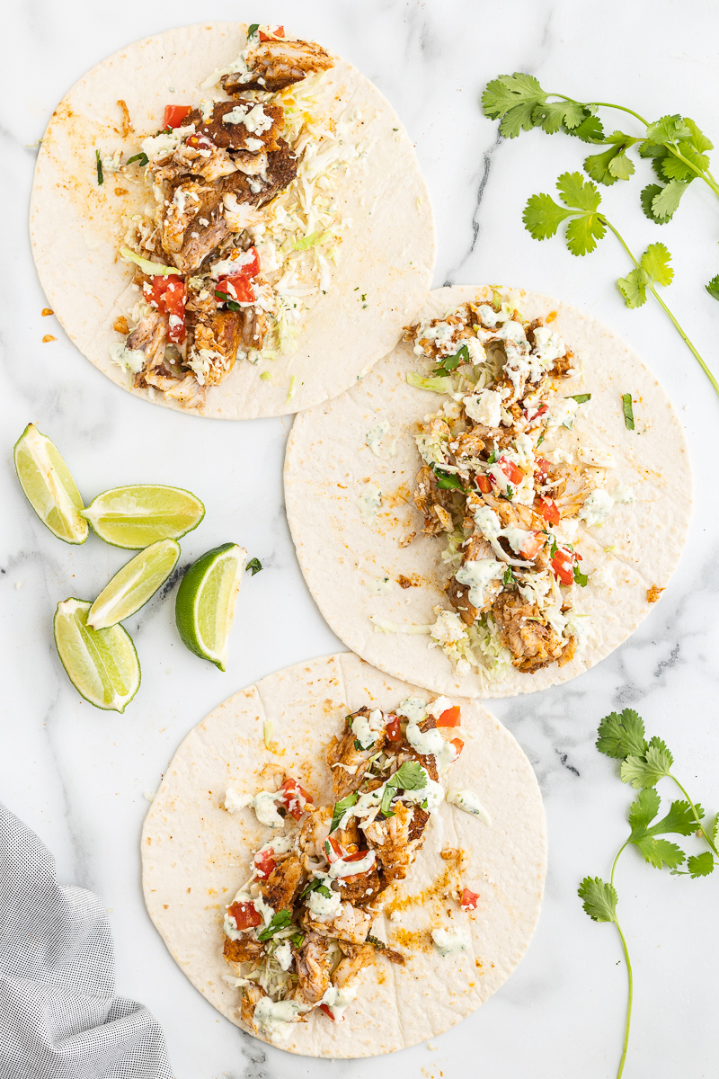 Overhead photo of open faced Keto Fish Tacos on a white marble counter.