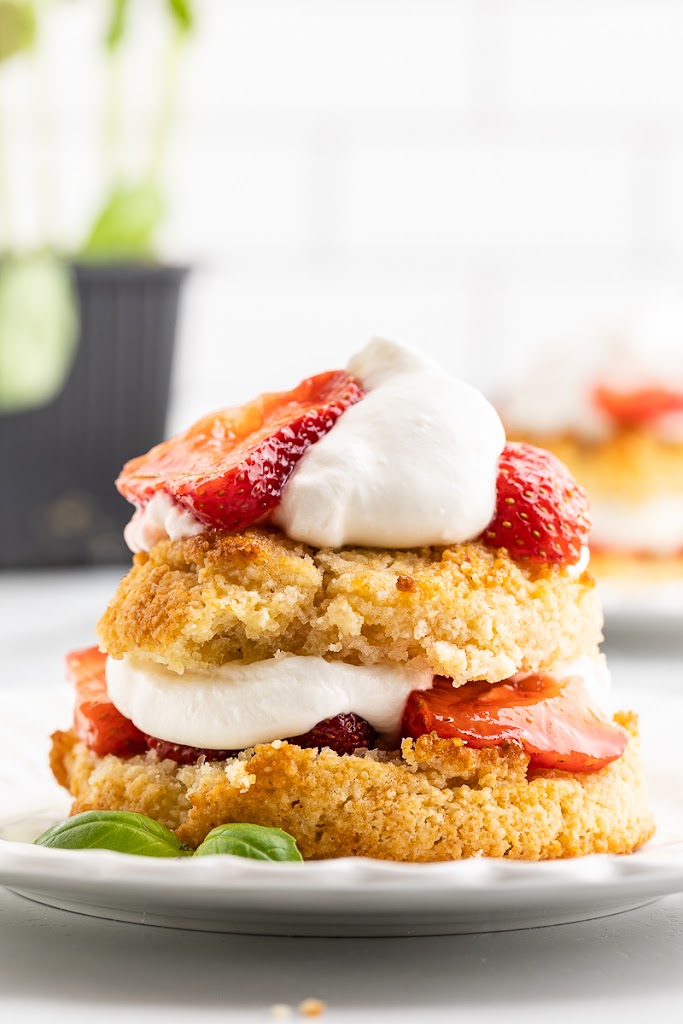 Side view of a keto strawberry basil shortcake on a white plate.