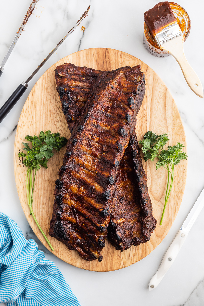 Overhead photo of cooked keto BBQ ribs on a wooden cutting board.