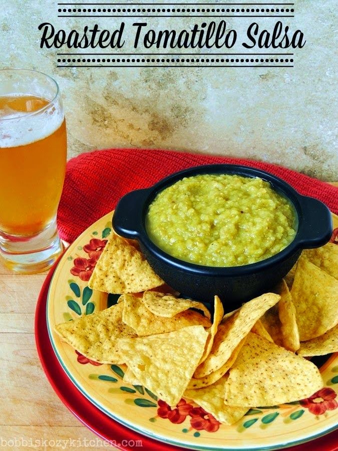 Image shows a Mexican inspired plate full of keto tortillas chips and a black bowl full of Roasted Tomatillo Salsa.