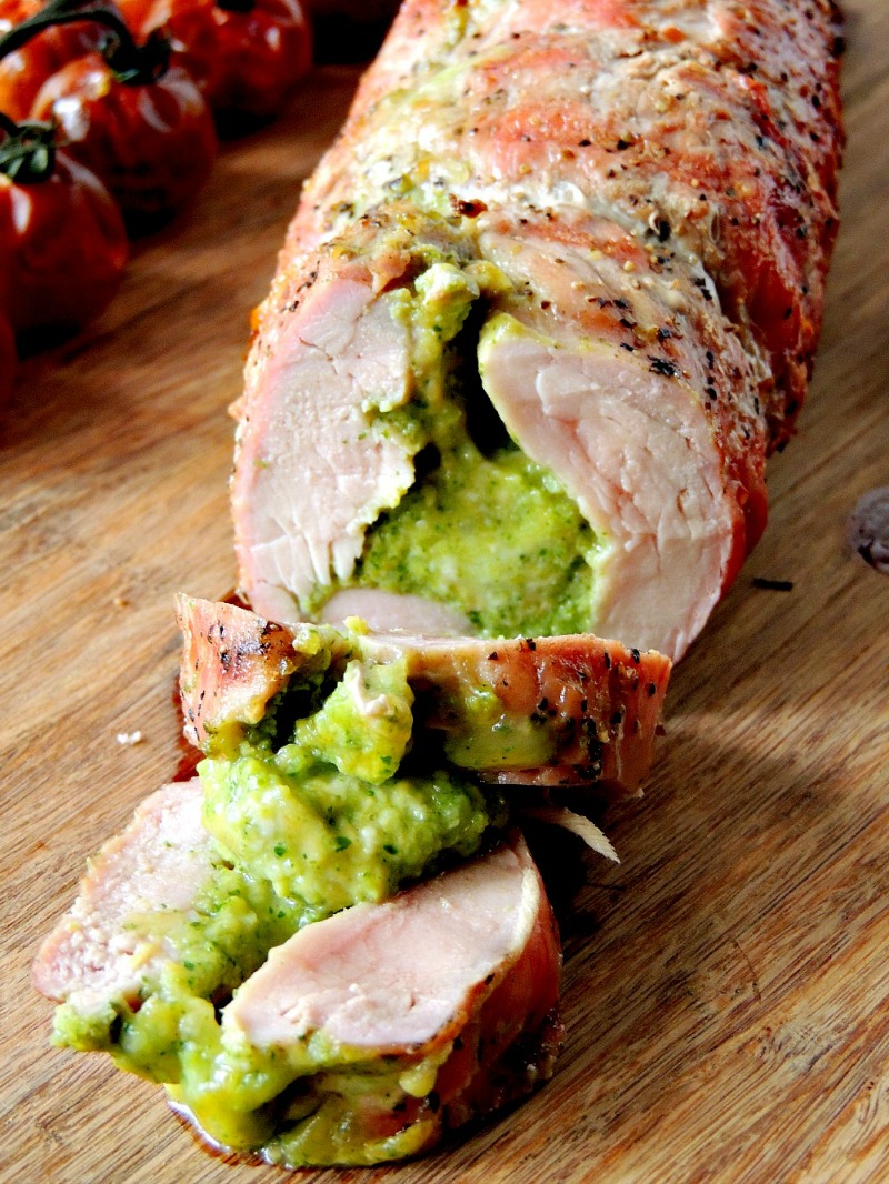 Broccoli Pesto and Cheese Stuffed Grilled Pork Tenderloin  on a wooden cutting board.