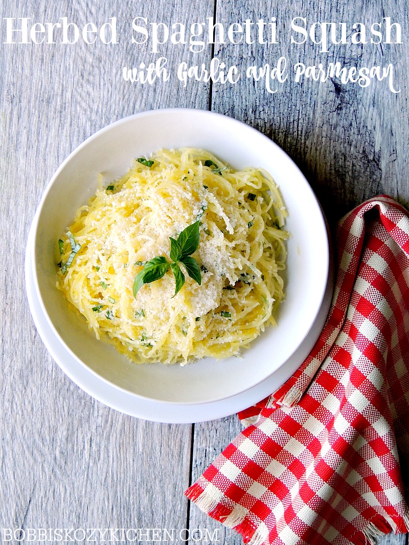 Herbed Spaghetti Squash with Garlic and Parmesan in a white bowl on a gray wood table.