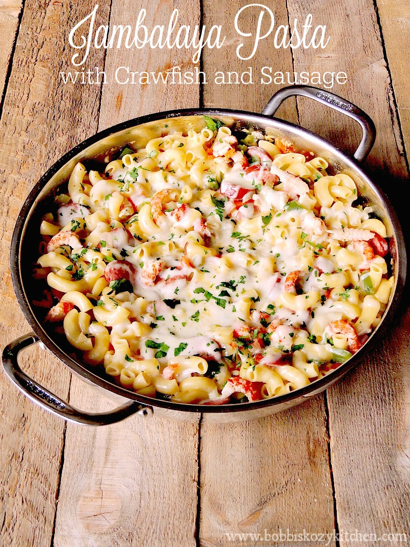 A silver skillet full of jambalaya pasta on a wooden table.