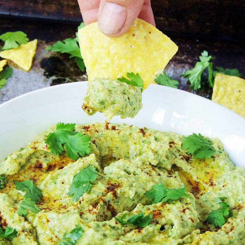 Roasted Jalapeno Hummus in a white bowl with a chip