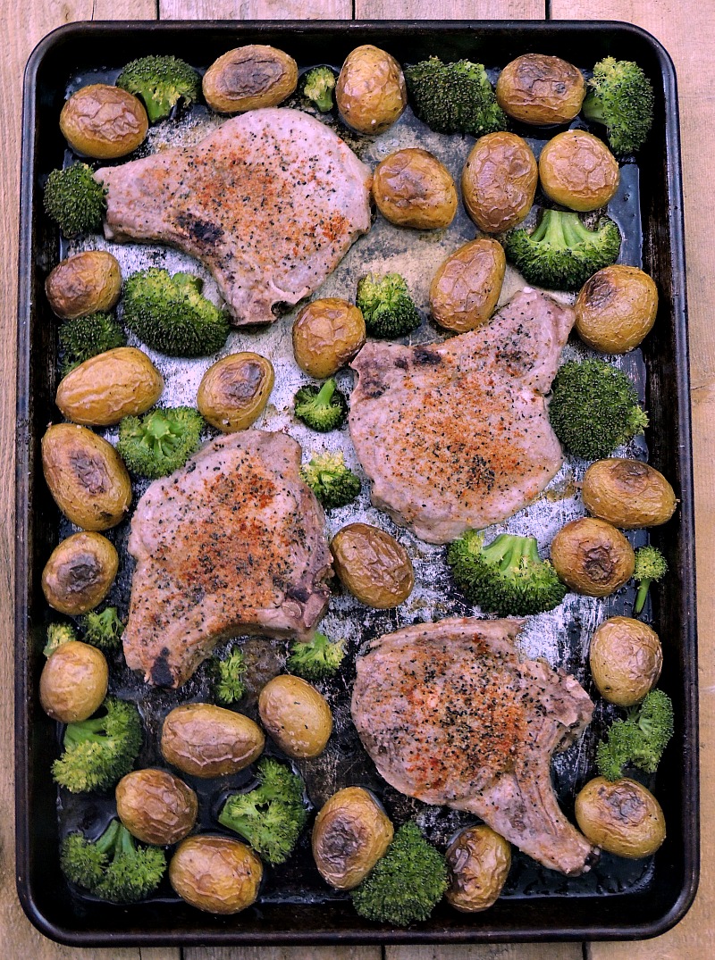 Sheet Pan Cajun Pork Chops with Potatoes and Broccoli on a metal sheet pan.