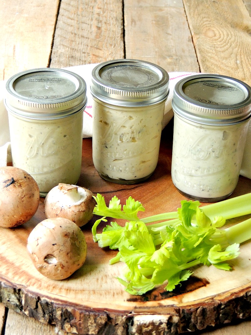 Keto condensed cream of mushroom, cream of chicken, and cream of celery soups in mason jars on a wooden cutting board.
