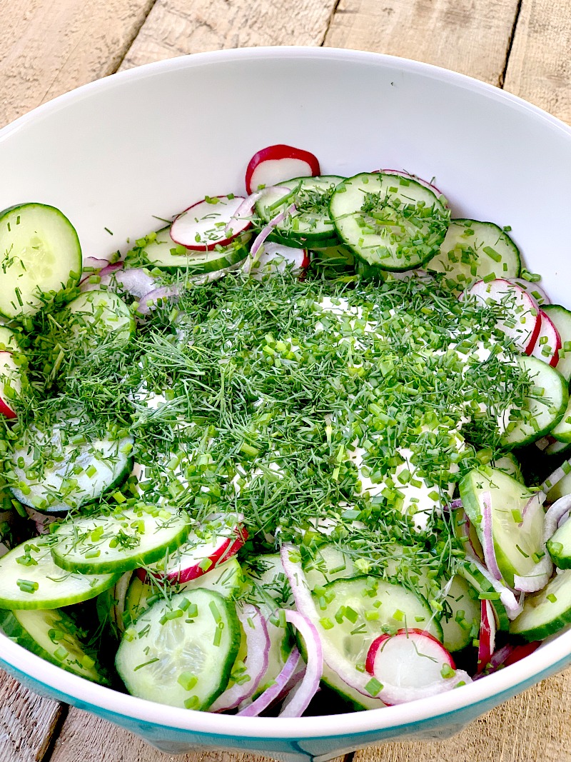 Chopped fresh dill and chives added to the other ingredients to make Creamy Low Carb Cucumber Salad.