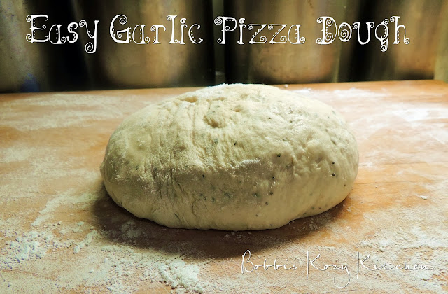 This easy garlic pizza dough recipe is simple to make and seriously the best-tasting pizza dough ever! #pizza #dough #easy #recipe | bobbiskozykitchen.com