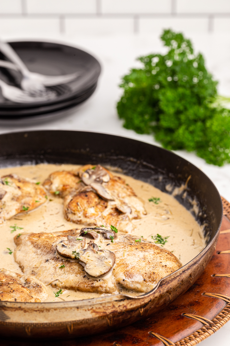 Closeup side shot of Chicken with Mushroom Garlic Sauce in a skillet.