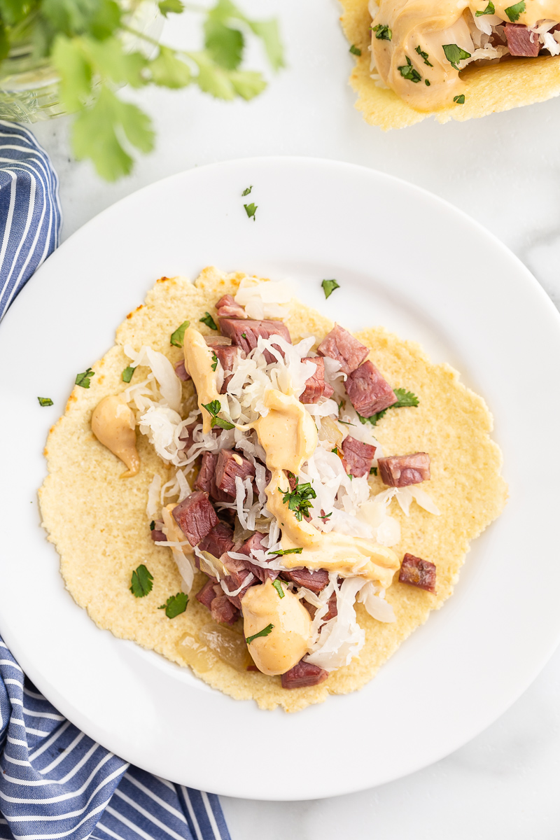 Overhead photo of a Keto Reuben Taco before folding on a white plate.