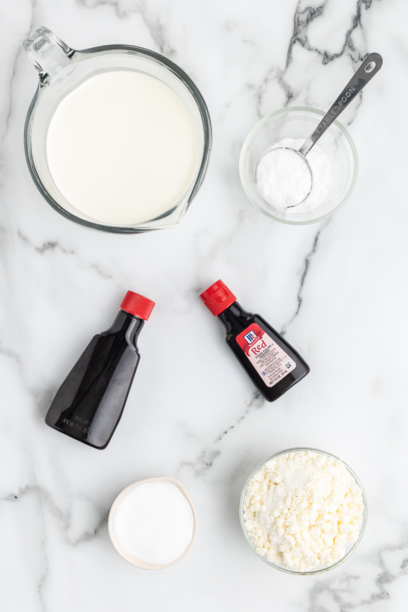 The ingredients need to make Keto Red Velvet Mousse on a white marble countertop.