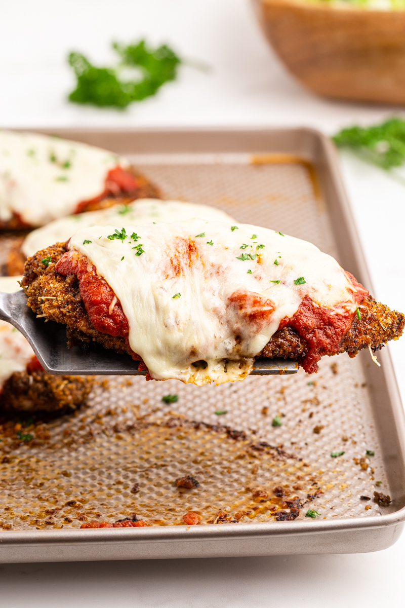 Closeup of a serving of Keto Sheet Pan Chicken Parmesan on a spatula.