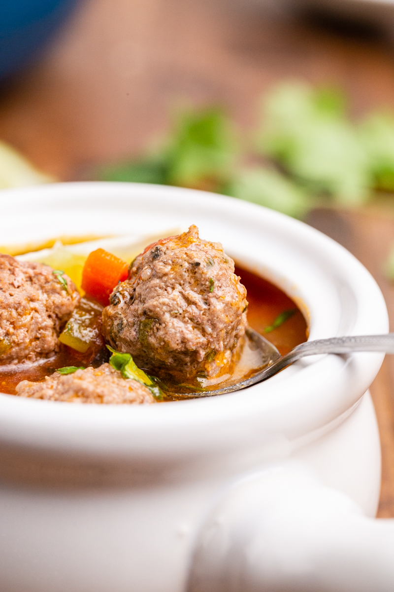 Keto albondigas (Mexican meatball) soup in a white crock with a handle.