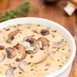 Keto Cream of Mushroom Soup in a white bowl on a wooden table.