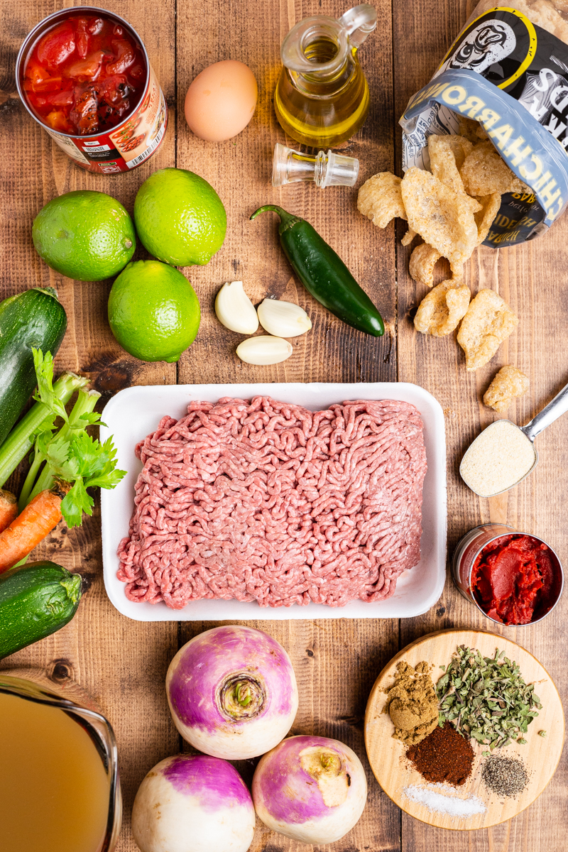 Overhead photo of the ingredients needed to make Keto Albondigas (Meatball) Soup on a wooden table.