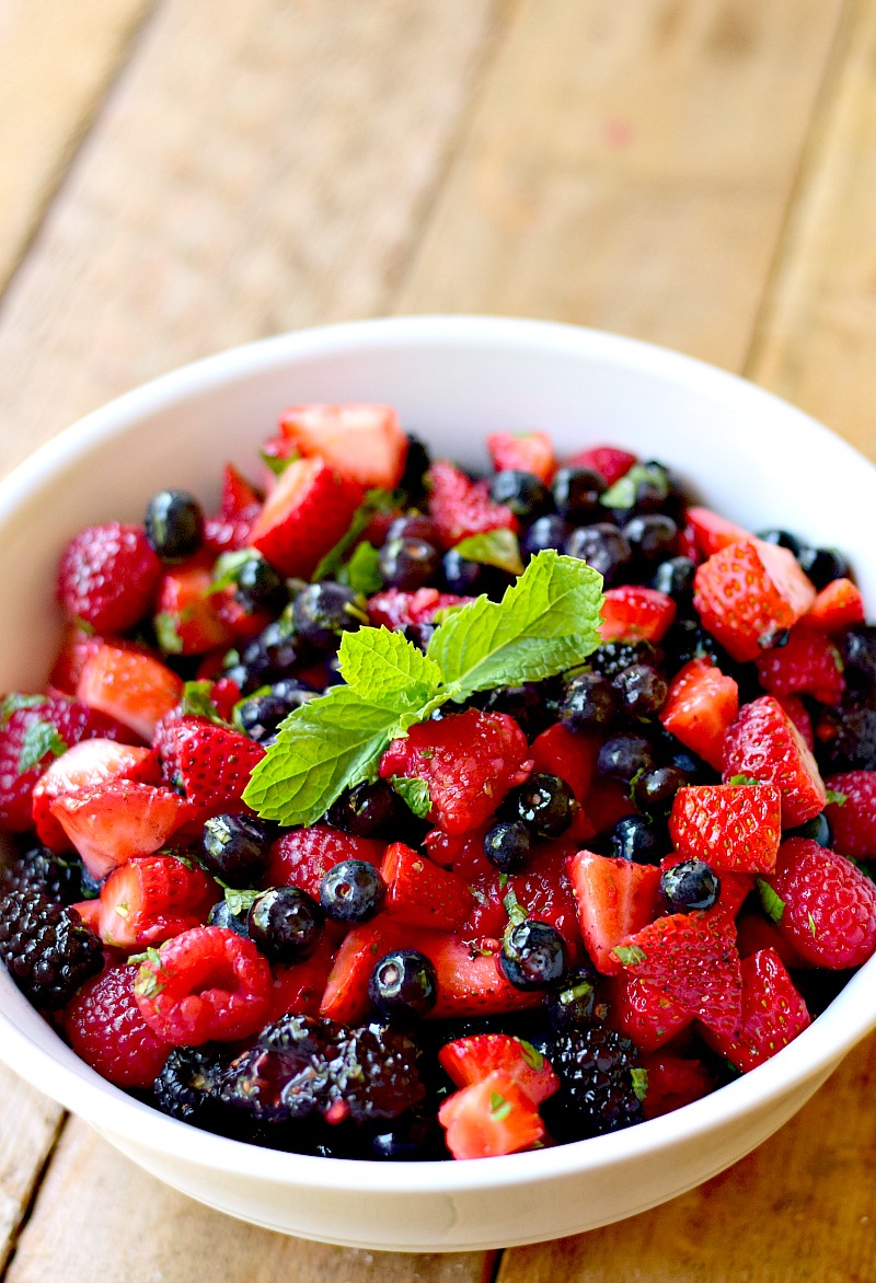 Overhead view of a delicious Mixed Berry Salad (Low Carb) in a bowl on a wooden table.