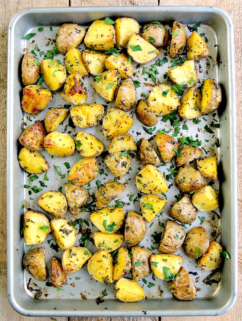 Crispy Rosemary Potato Bites on a sheet pan with a wooden background.