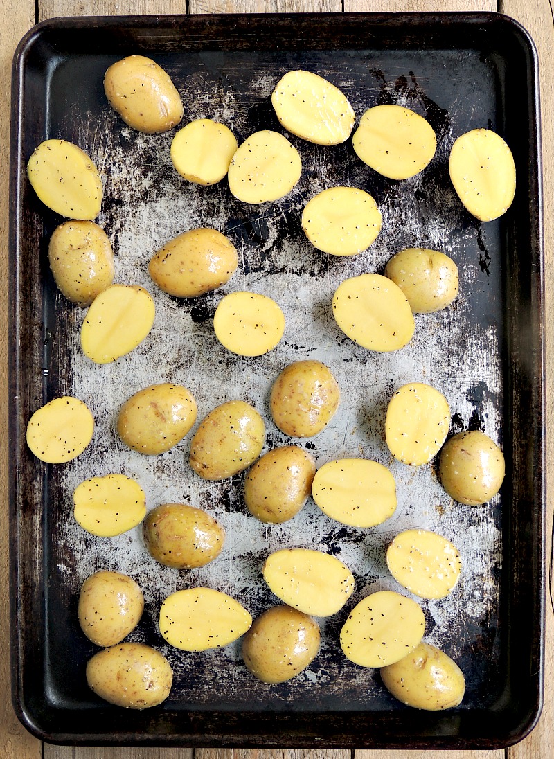 Halved baby Yukon gold potatoes on a sheet pan.