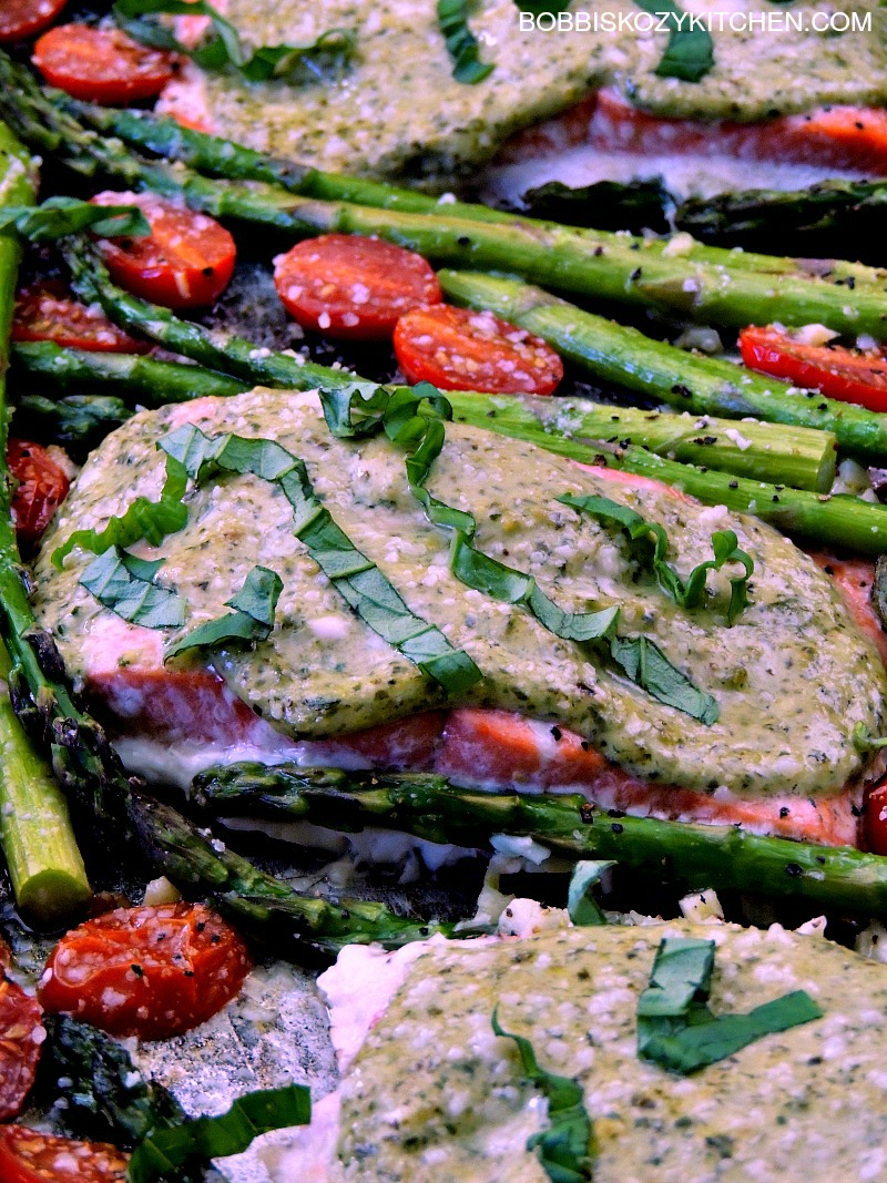This Sheet Pan Pesto Salmon with Asparagus and Tomatoes recipe super easy, and done in less than 30 minutes, but doesn't scrimp on taste. A perfect weekday supper the whole family will love. #keto #lowcarb #sheetpan #onepot #onepan #30minuterecipe #easy #salmon #pesto #asparagus #tomatoes #recipe |   bobbiskozykitchen.com